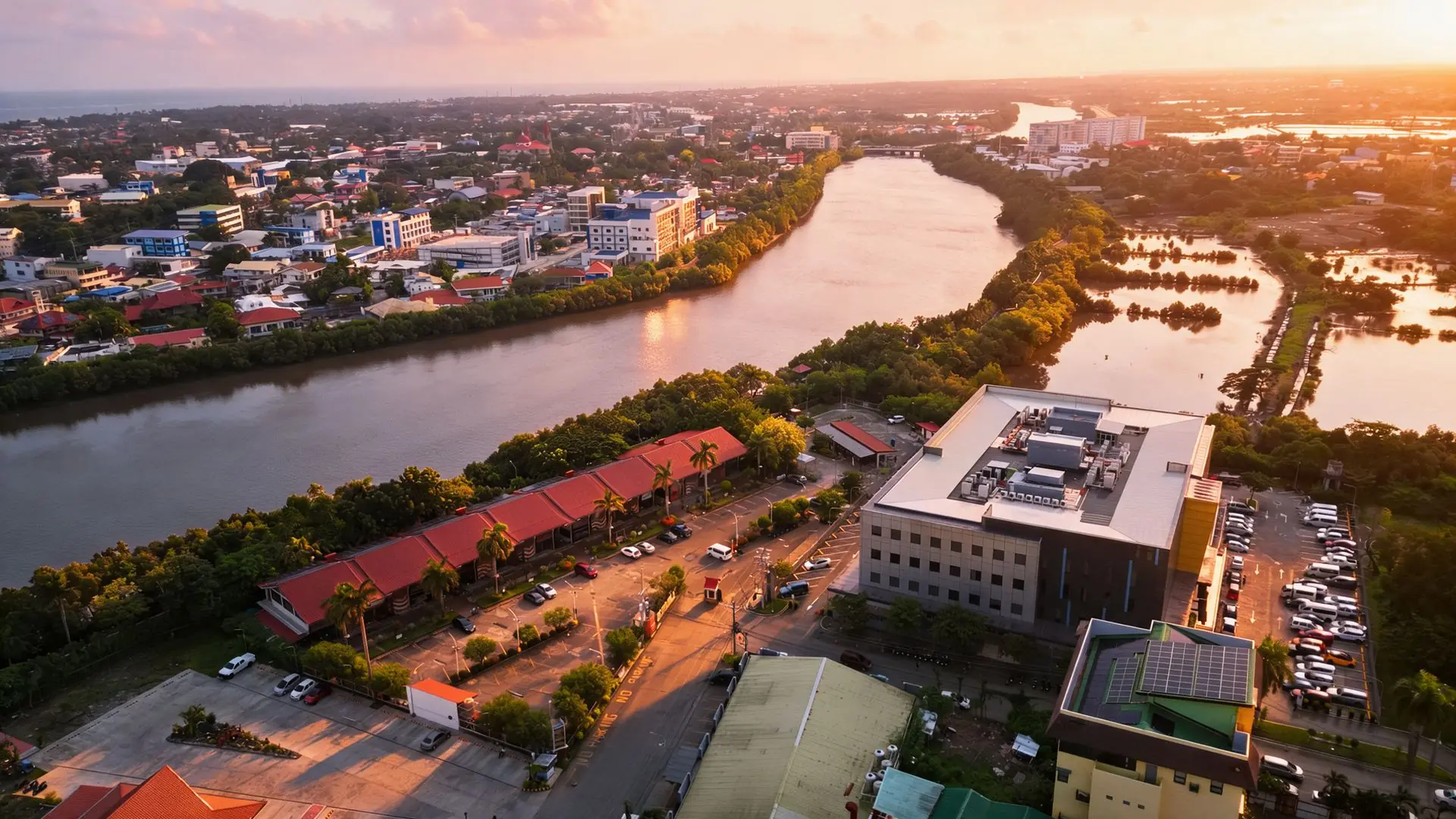 Riverside Iloilo from above at sunset: the red-roofed buildings along the Iloilo River, with the city behind